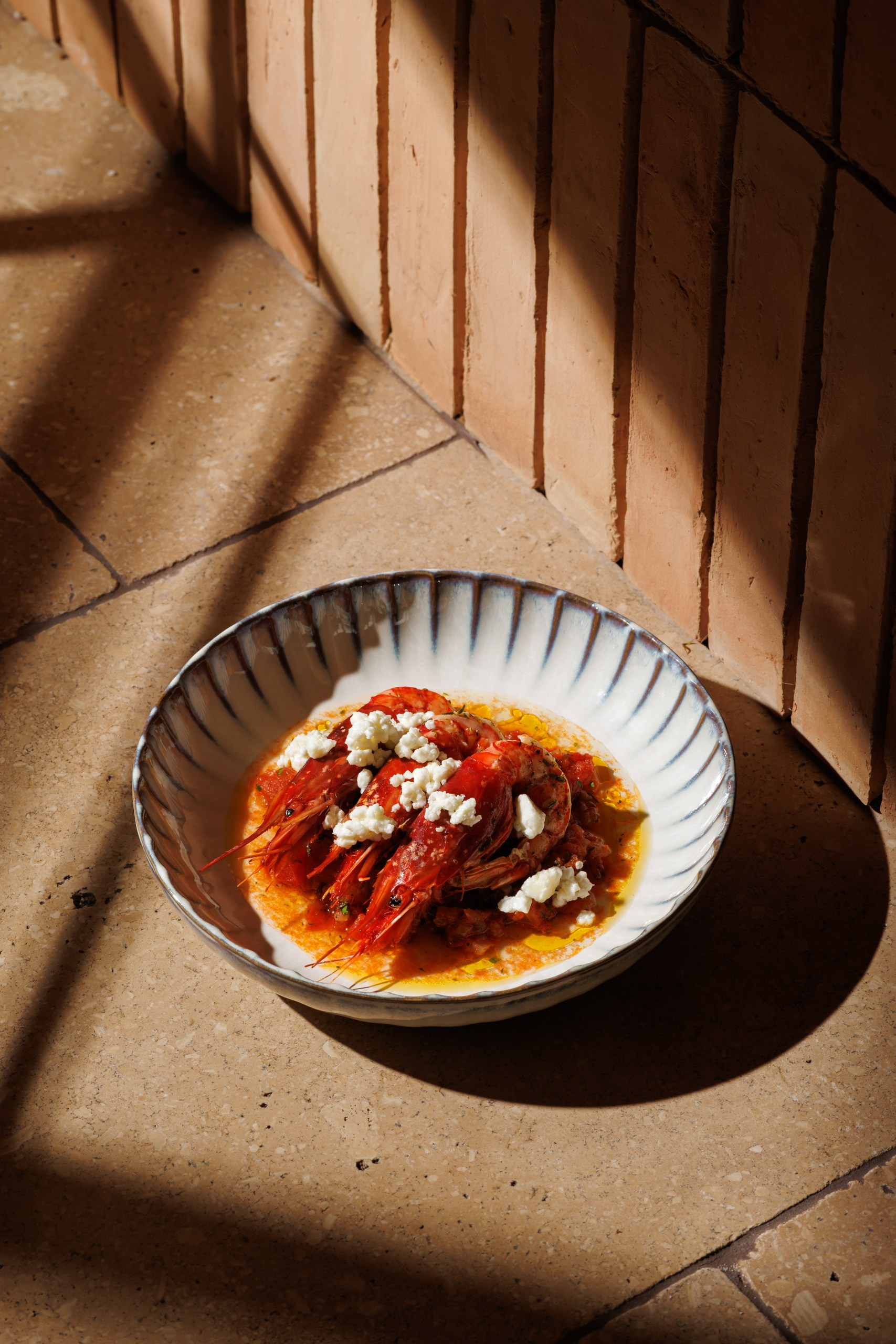 Mazara red prawns with tomato and feta on terracotta tiles
